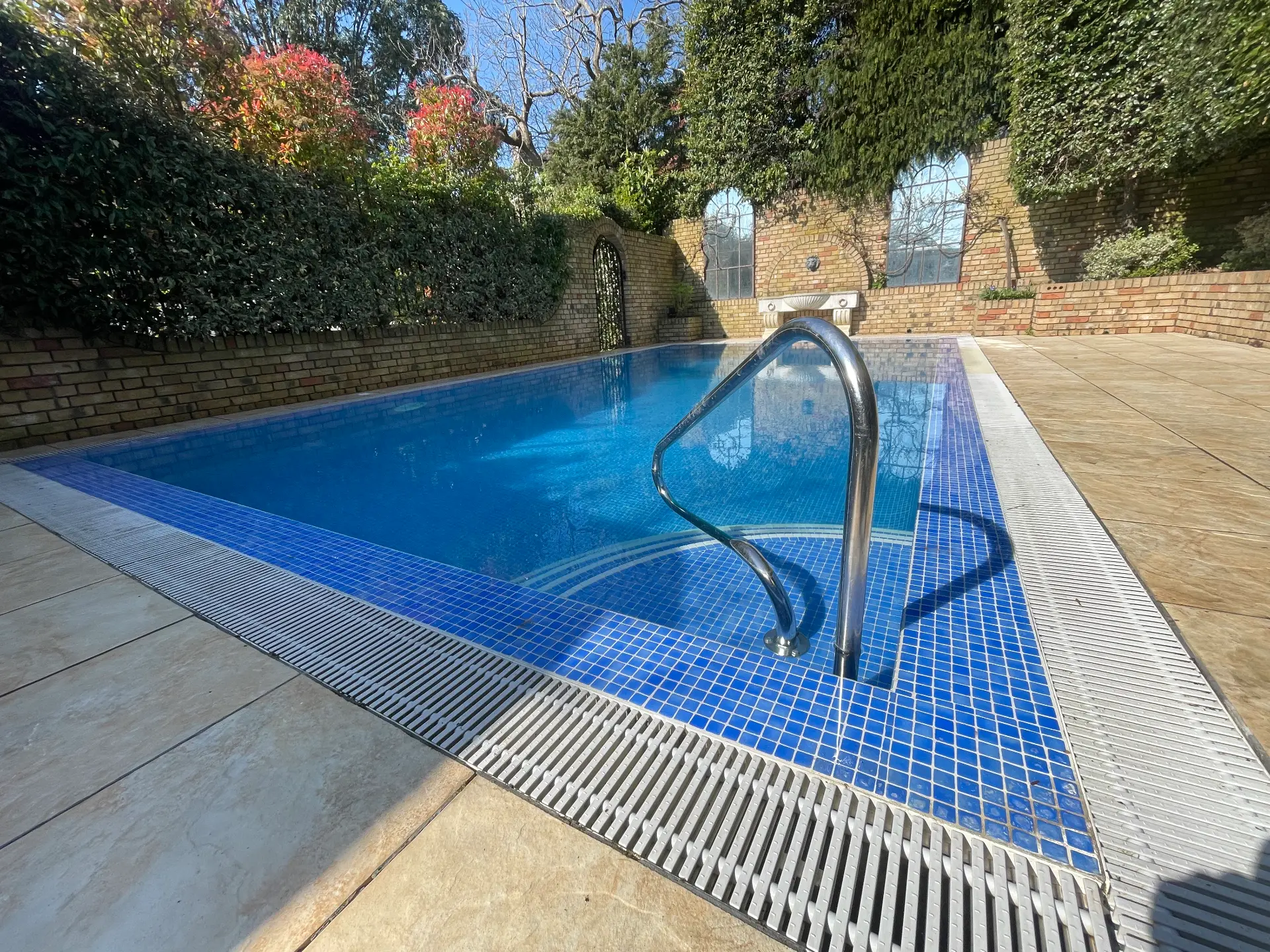 Fully tiled pool with brick surround and Roman steps
