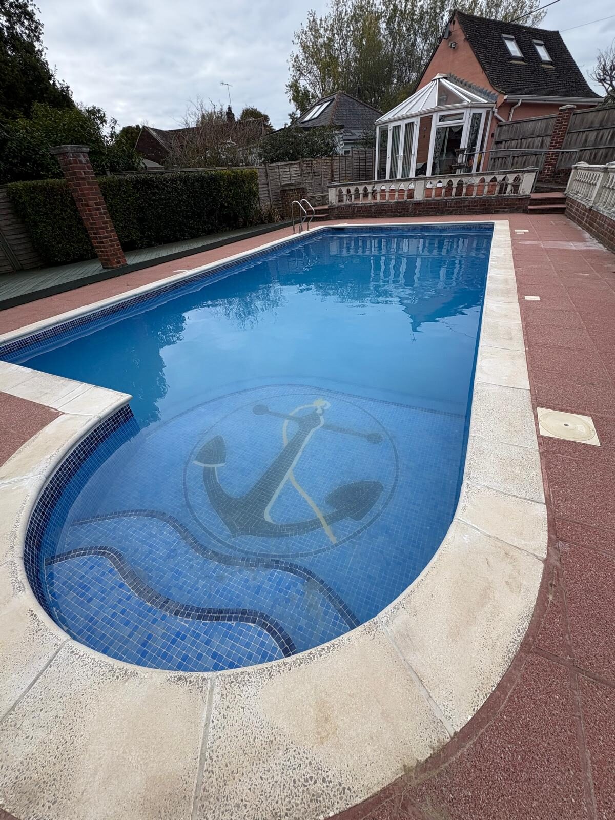 Garden swimming pool with a hand-laid anchor mosaic on the pool floor
