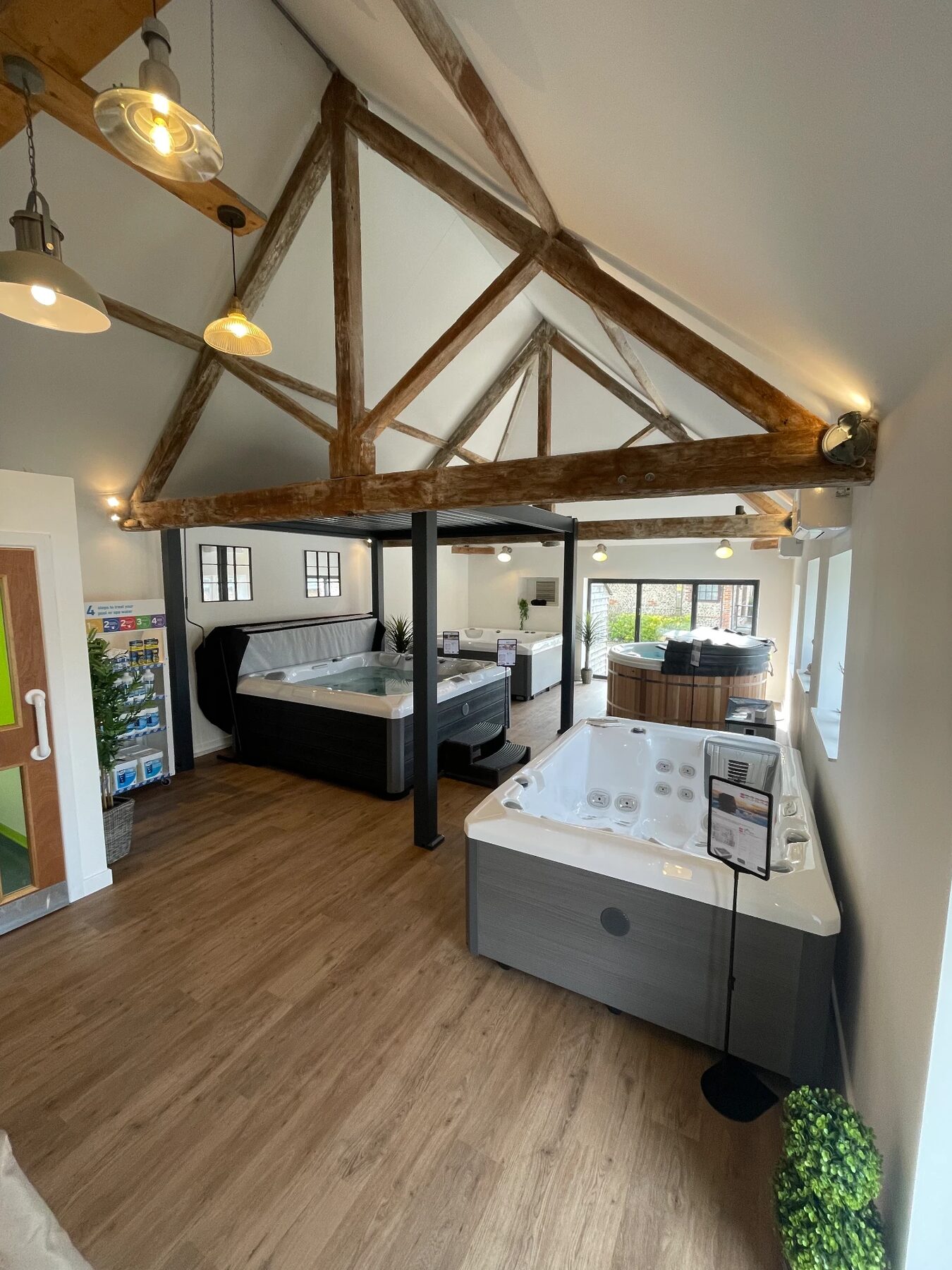 Inside the StarLuxe showroom, with hot tubs and a wood-fired tub beneath exposed beams